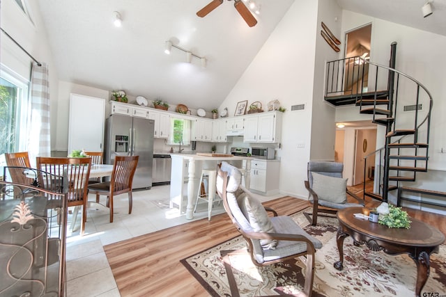 506 S King Lake Rd, Scroggins, TX 75480 - living area featuring stairs, high vaulted ceiling, ceiling fan, light wood finished floors, and rail lighting