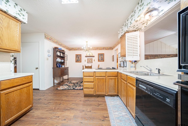 kitchen with sink, kitchen peninsula, hardwood / wood-style floors, and black dishwasher