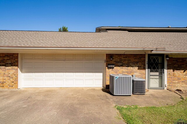 exterior space with central AC and a garage