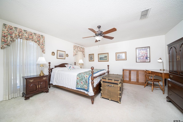 bedroom featuring ceiling fan, a textured ceiling, and light colored carpet