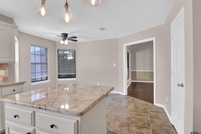 314 Briarcrest Dr, Chandler, TX 75758 - kitchen featuring visible vents, ceiling fan, a center island, white cabinets, and baseboards