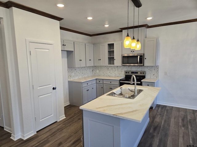 kitchen with decorative light fixtures, a center island with sink, appliances with stainless steel finishes, dark hardwood / wood-style flooring, and light stone countertops