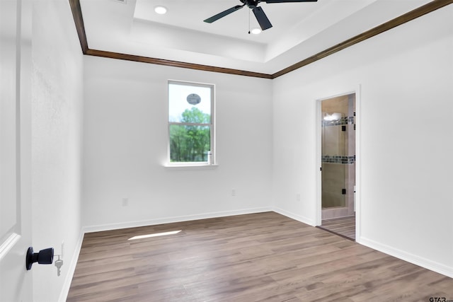unfurnished bedroom featuring connected bathroom, baseboards, crown molding, and wood finished floors