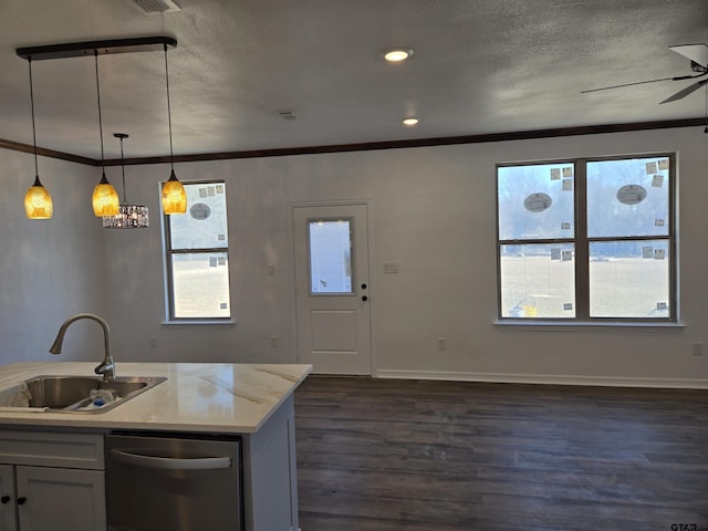 kitchen with ornamental molding, sink, pendant lighting, and light stone counters