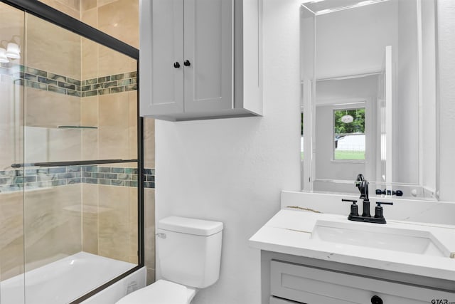 full bath with vanity, a shower with shower door, and toilet