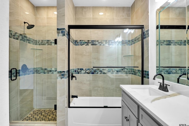 bathroom with tiled shower / bath, vanity, and tile walls