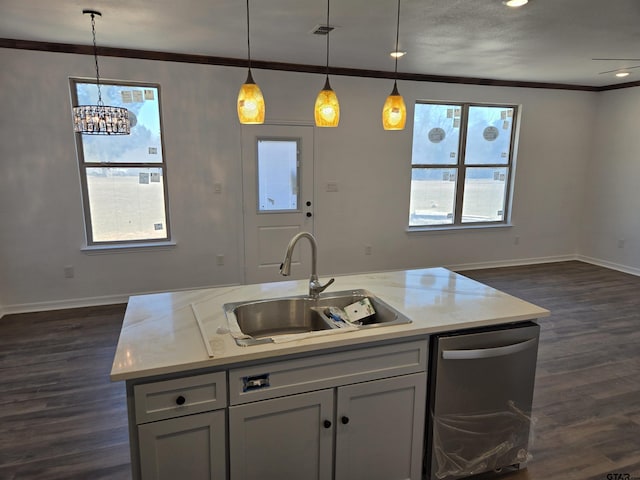 kitchen featuring dishwasher, sink, hanging light fixtures, a kitchen island with sink, and light stone counters