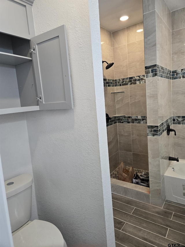 bathroom featuring toilet and a tile shower