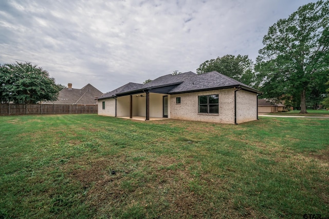 back of property featuring a patio area and a lawn