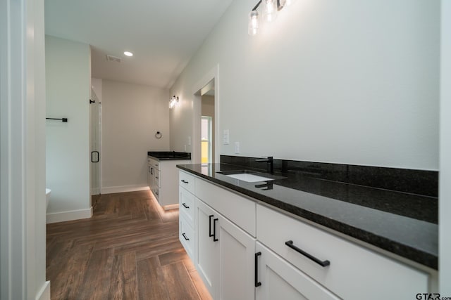 bathroom featuring a shower with door and vanity