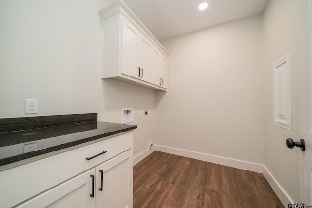 laundry area with hookup for an electric dryer, dark hardwood / wood-style flooring, hookup for a washing machine, and cabinets