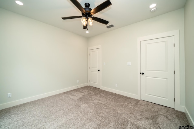 carpeted spare room featuring ceiling fan