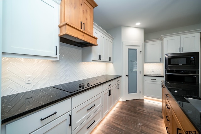 kitchen with dark stone counters, dark hardwood / wood-style floors, white cabinetry, and black appliances