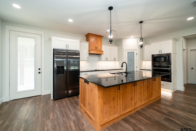 kitchen featuring dark wood-type flooring, white cabinetry, appliances with stainless steel finishes, and an island with sink