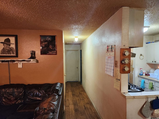 corridor featuring a textured ceiling and hardwood / wood-style floors