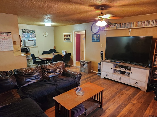 living room with a textured ceiling, ceiling fan, cooling unit, and hardwood / wood-style floors