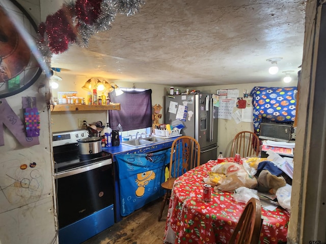 kitchen featuring a textured ceiling, appliances with stainless steel finishes, wood-type flooring, and sink