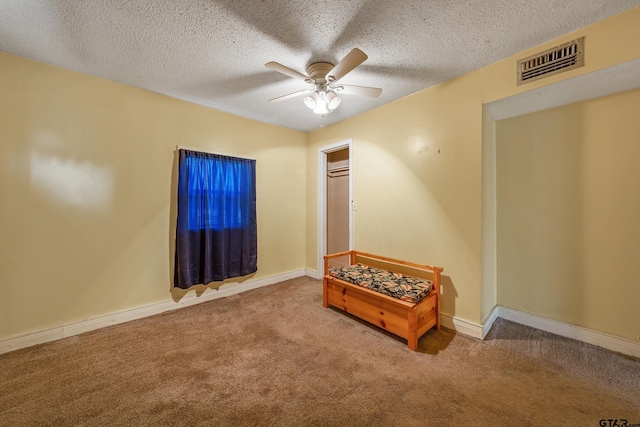 interior space with carpet floors, a textured ceiling, and ceiling fan