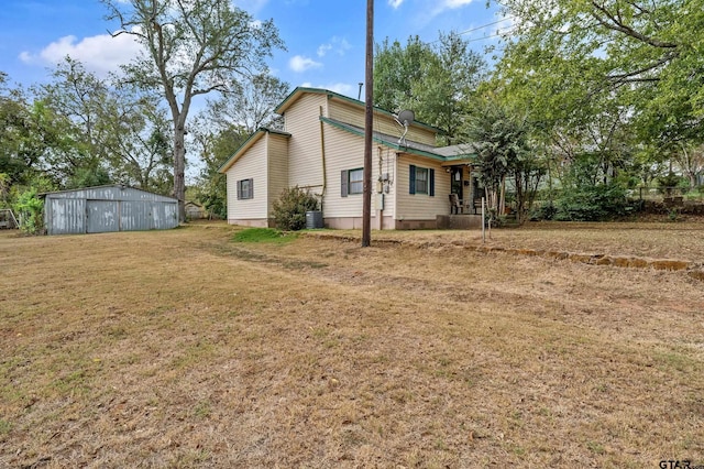 back of property with an outbuilding and a lawn