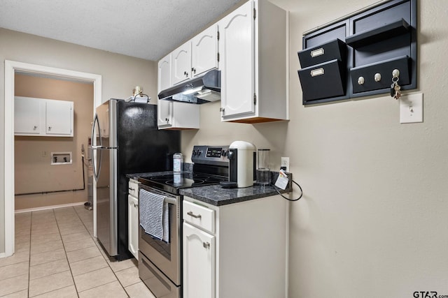 18396 Tall Pines Dr, Tyler, TX 75703 - kitchen with under cabinet range hood, appliances with stainless steel finishes, white cabinets, dark countertops, and light tile patterned floors