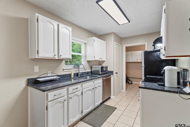 18396 Tall Pines Dr, Tyler, TX 75703 - kitchen with a sink, stainless steel appliances, white cabinetry, light tile patterned floors, and dark stone counters