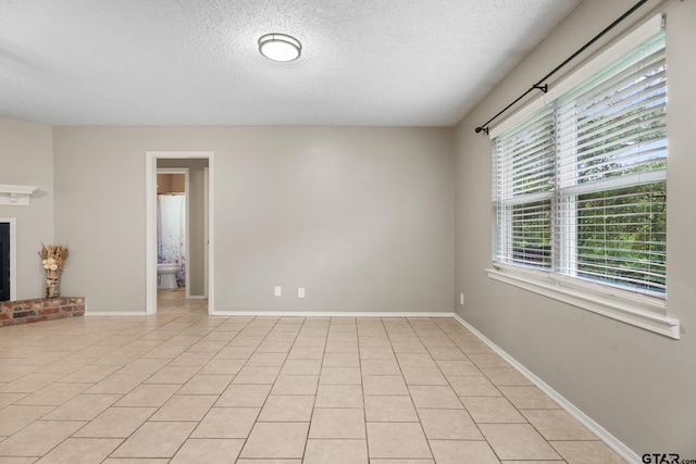 18396 Tall Pines Dr, Tyler, TX 75703 - unfurnished room featuring a textured ceiling, light tile patterned flooring, and baseboards