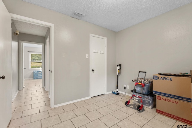 18396 Tall Pines Dr, Tyler, TX 75703 - washroom with a textured ceiling, light tile patterned floors, and baseboards