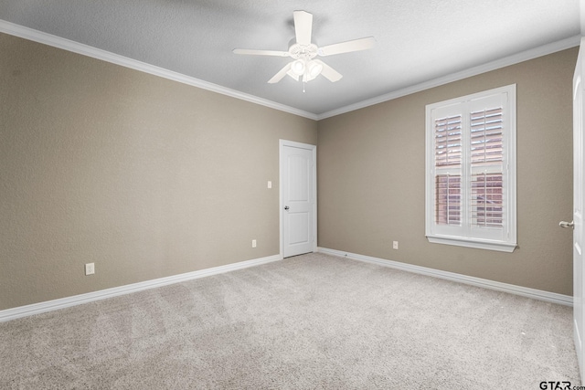 unfurnished room featuring baseboards, light colored carpet, ornamental molding, a textured ceiling, and a ceiling fan