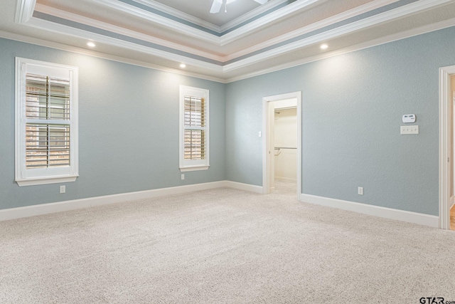 carpeted empty room featuring a ceiling fan, baseboards, recessed lighting, crown molding, and a raised ceiling