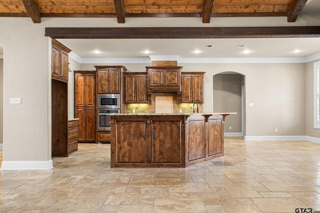 kitchen with stone tile floors, baseboards, arched walkways, stainless steel appliances, and beamed ceiling