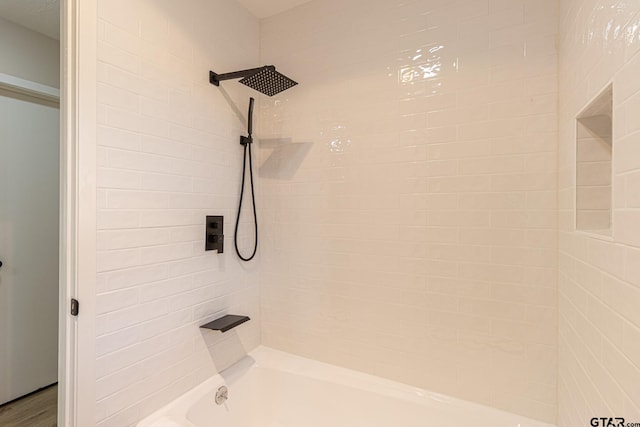 bathroom featuring wood-type flooring and tiled shower / bath combo