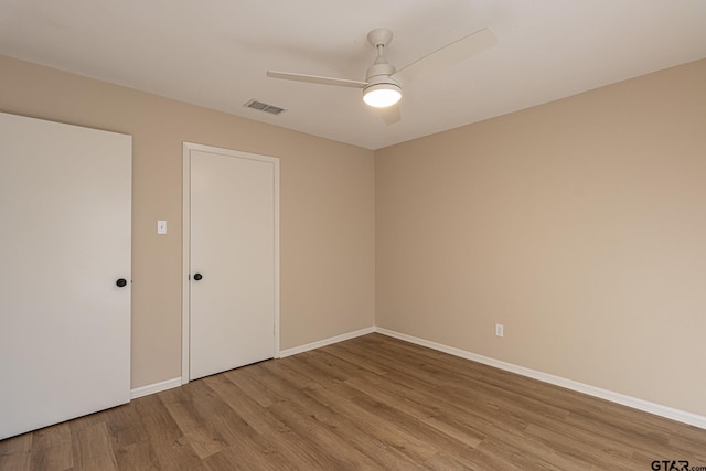 unfurnished room with ceiling fan and hardwood / wood-style flooring