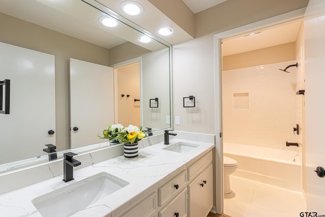 full bathroom featuring tile patterned floors, tiled shower / bath, vanity, and toilet