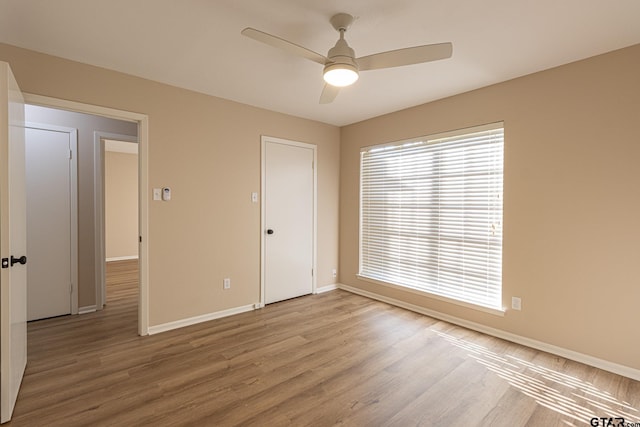 spare room with ceiling fan and light wood-type flooring