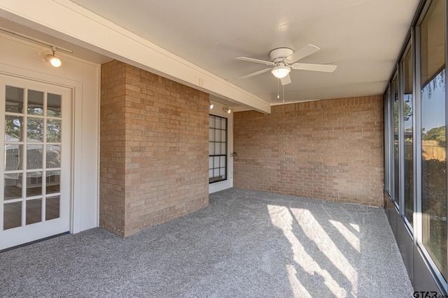 unfurnished sunroom with ceiling fan