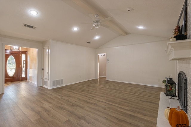 unfurnished living room with vaulted ceiling with beams, ceiling fan, dark hardwood / wood-style floors, and a brick fireplace