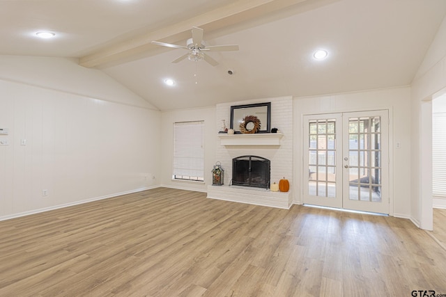 unfurnished living room with french doors, vaulted ceiling with beams, ceiling fan, a fireplace, and light hardwood / wood-style floors