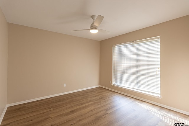 spare room with ceiling fan and wood-type flooring