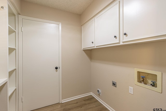 clothes washing area featuring cabinets, hardwood / wood-style flooring, washer hookup, a textured ceiling, and hookup for an electric dryer