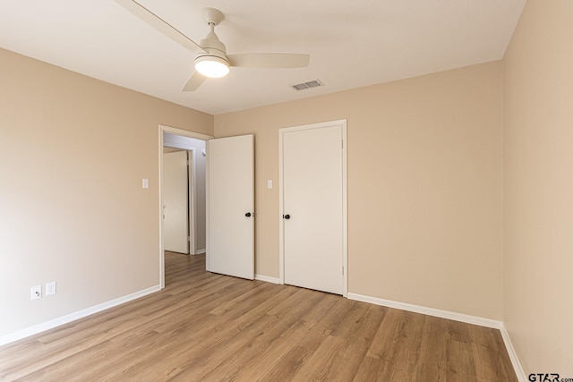 unfurnished bedroom featuring ceiling fan, light hardwood / wood-style floors, and a closet