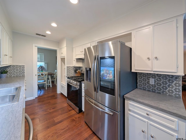 kitchen featuring dark wood-type flooring, white cabinets, sink, decorative backsplash, and appliances with stainless steel finishes