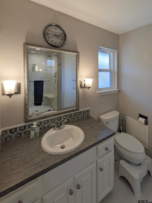 bathroom with tile patterned flooring, a shower, vanity, and toilet