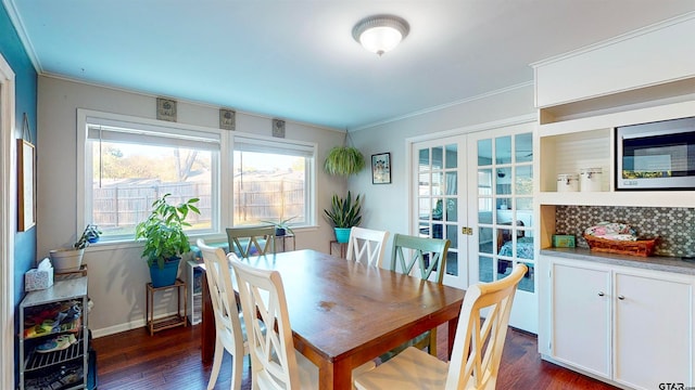 dining room with dark hardwood / wood-style flooring, crown molding, and french doors