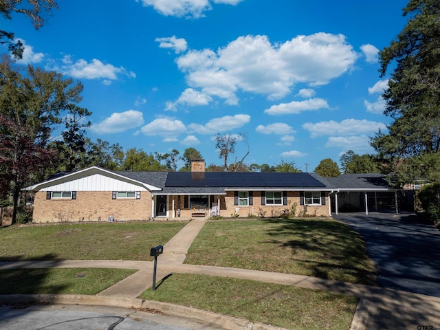 single story home featuring a front lawn, covered porch, and a carport