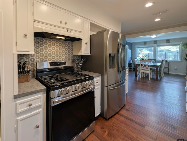 kitchen featuring dark hardwood / wood-style floors, ornamental molding, tasteful backsplash, white cabinetry, and stainless steel appliances