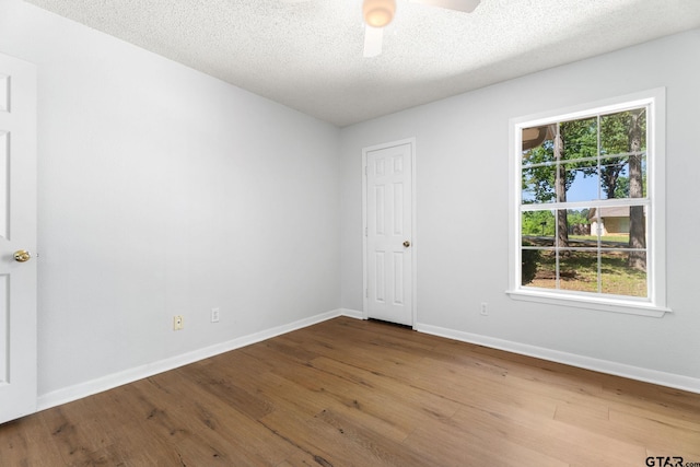 empty room with baseboards, a ceiling fan, and wood finished floors