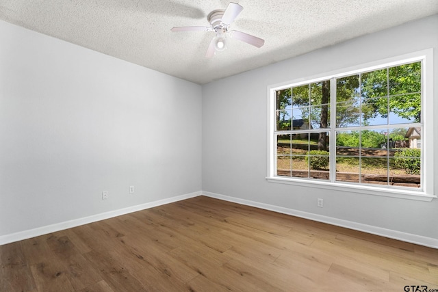 unfurnished room featuring a ceiling fan, wood finished floors, and a textured ceiling