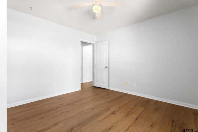 unfurnished room featuring wood finished floors, baseboards, a textured ceiling, and a ceiling fan