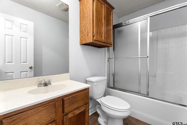 bathroom with wood finished floors, a textured ceiling, vanity, and toilet