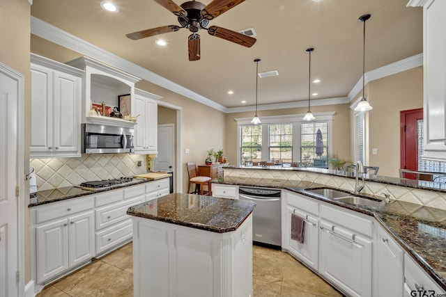 kitchen with stainless steel appliances, white cabinetry, sink, kitchen peninsula, and decorative light fixtures